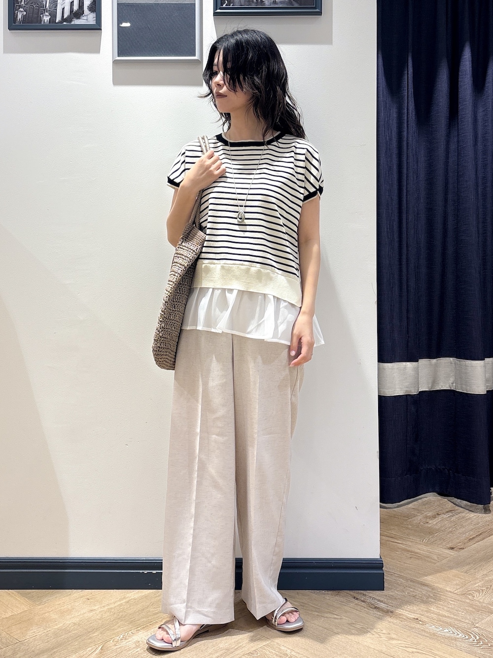ホワイト系のニット/セーター、ベージュ系のその他パンツ、ブラウン系のトートバッグを着用したレディースの夏コーディネートの1枚目の写真