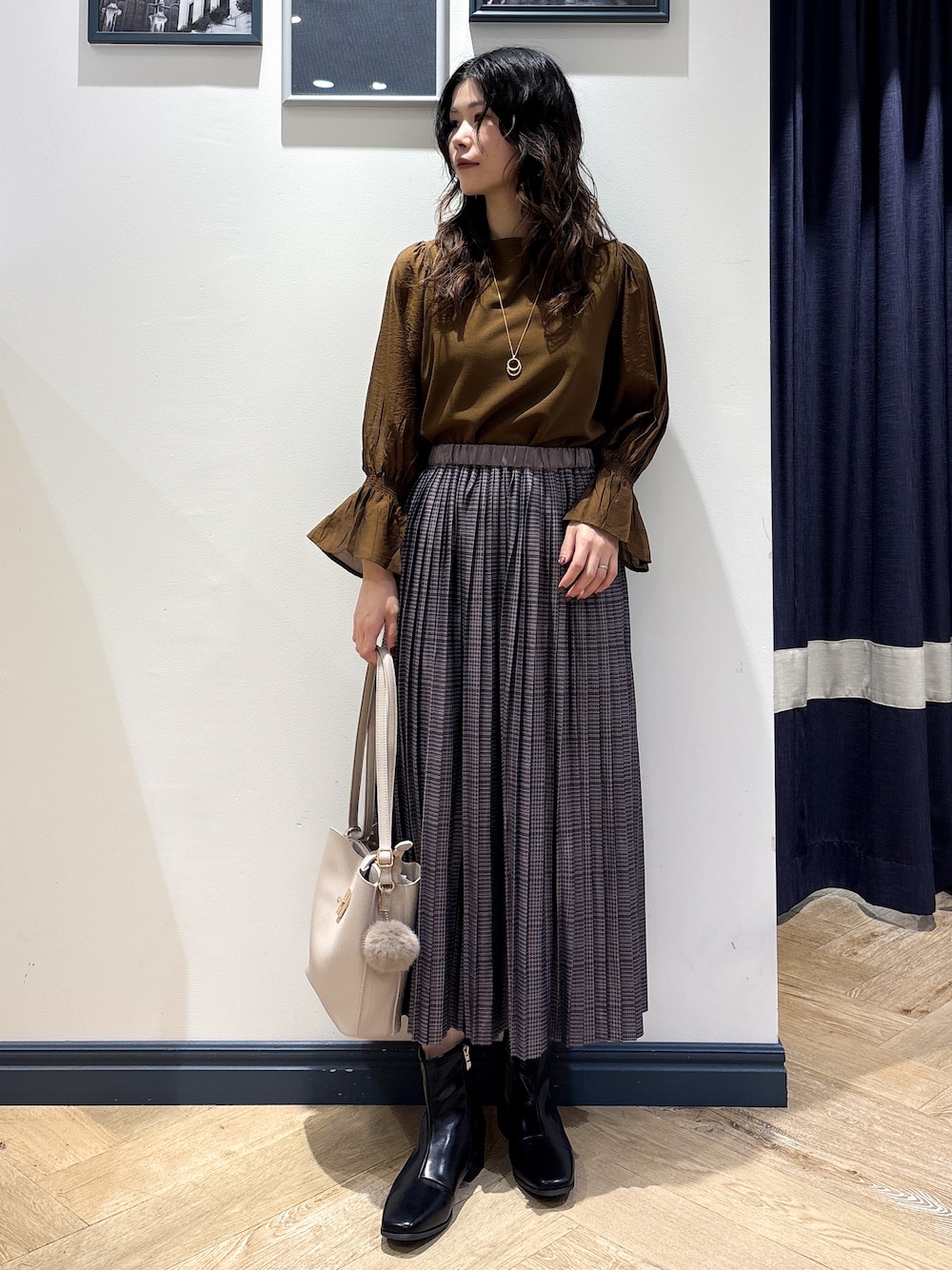 ブラウン系のTシャツ/カットソー、グレー系のスカート、ベージュ系のショルダーバッグを着用したレディースの秋コーディネートの1枚目の写真
