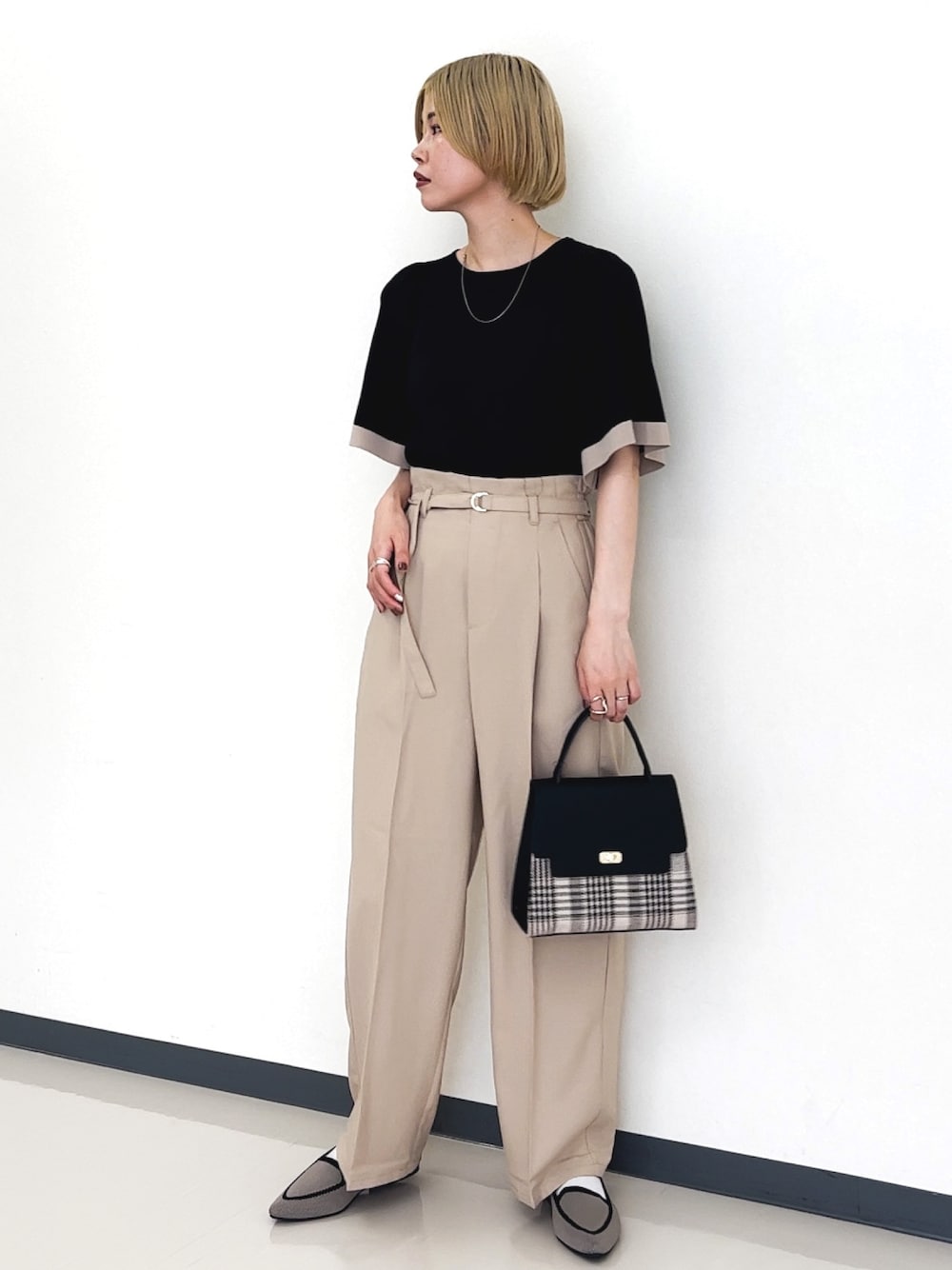 ブラック系のニット/セーター、ベージュ系のその他パンツ、ブラック系のショルダーバッグを着用したレディースの夏コーディネートの1枚目の写真