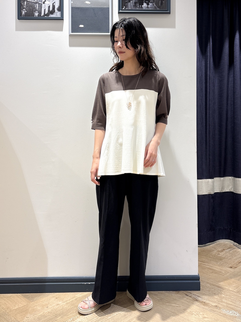 ベージュ系のニット/セーター、ブラック系のその他パンツ、ゴールド系のネックレスを着用したレディースの夏コーディネートの1枚目の写真
