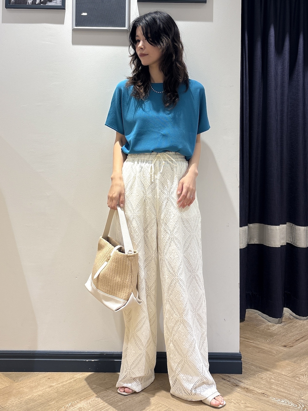 ブルー系のニット/セーター、ホワイト系のその他パンツ、ホワイト系のショルダーバッグを着用したレディースの夏コーディネートの1枚目の写真