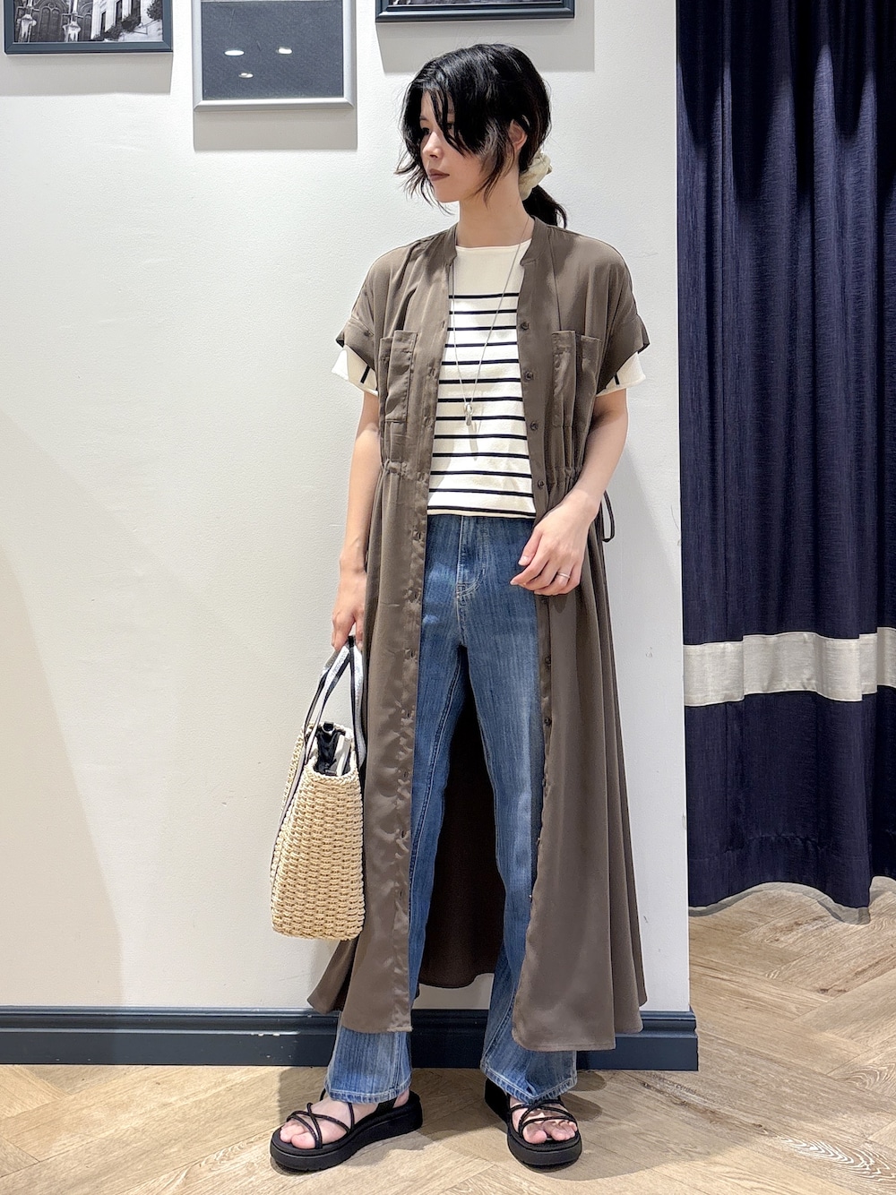 ブラウン系のワンピース、ホワイト系のニット/セーター、ブルー系のデニムパンツを着用したレディースの夏コーディネートの1枚目の写真