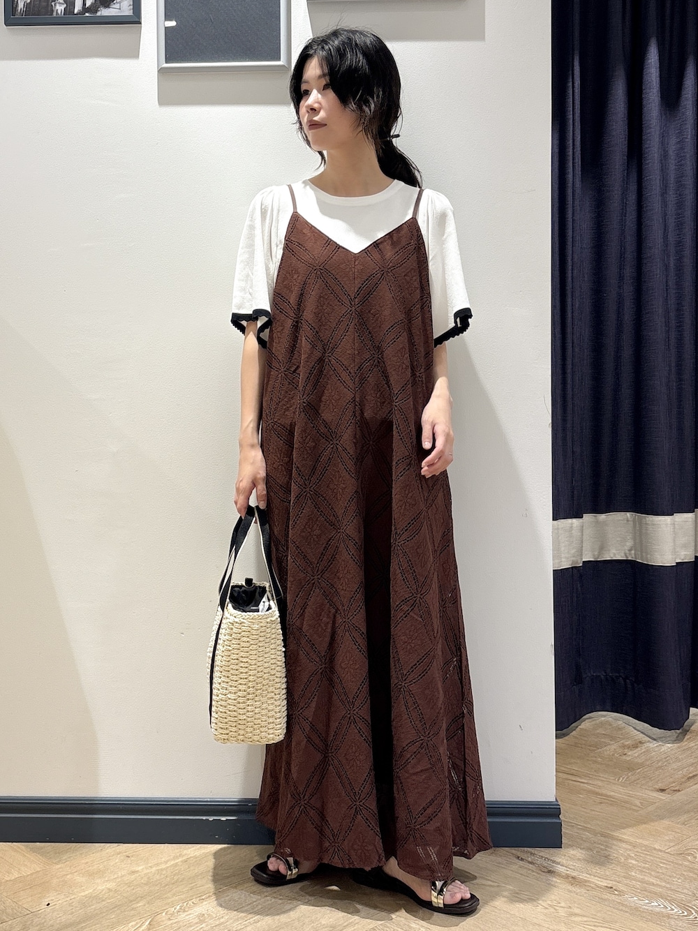 ホワイト系のニット/セーター、ブラウン系のワンピース、ホワイト系のトートバッグを着用したレディースの春コーディネートの1枚目の写真