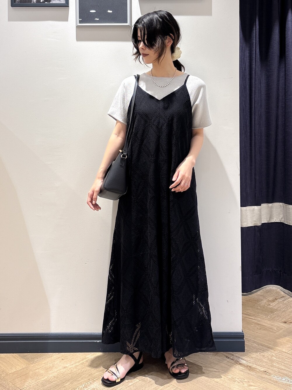 シルバー系のニット/セーター、ブラック系のワンピース、ブラック系のショルダーバッグを着用したレディースの夏コーディネートの1枚目の写真