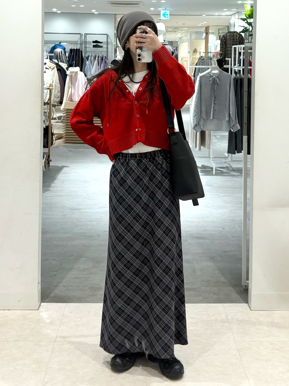 ブルー系のスカート、ホワイト系のTシャツ/カットソー、レッド系のニット/セーターを着用したレディースの秋コーディネートの1枚目の写真