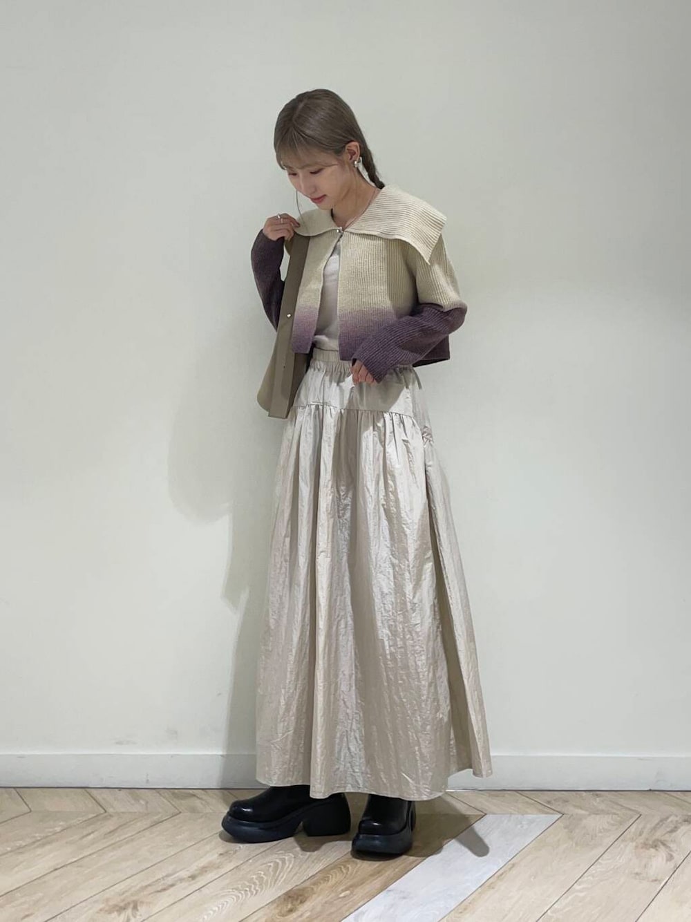 ベージュ系のキャミソール、ブラウン系のニット/セーター、ベージュ系のハンドバッグを着用したレディースの秋コーディネートの1枚目の写真