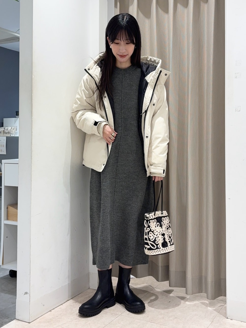 ホワイト系のダウンジャケット/コート、グレー系のワンピース、ブラック系のハンドバッグを着用したレディースの冬コーディネートの1枚目の写真