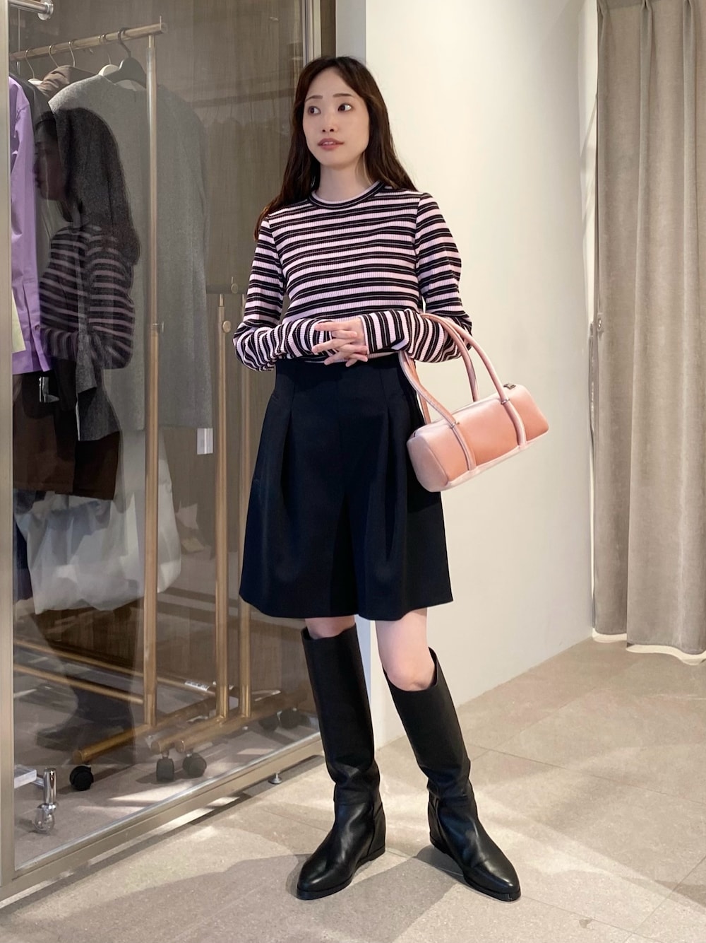 ピンク系のTシャツ/カットソー、ピンク系のハンドバッグ、ブラック系のスラックスを着用したレディースの秋コーディネートの1枚目の写真