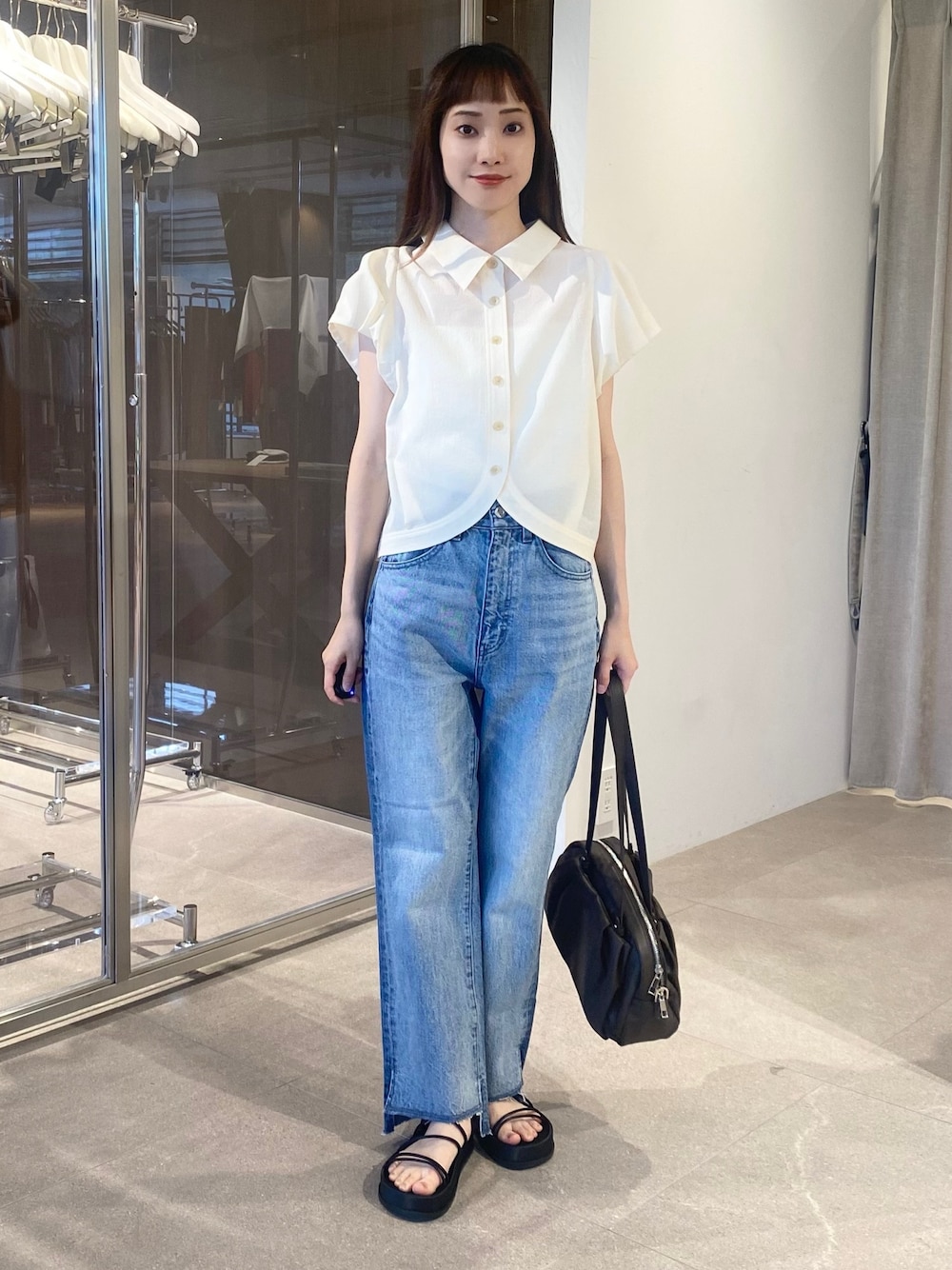 ホワイト系のシャツ/ブラウス、ブルー系のデニムパンツ、ブラック系のショルダーバッグを着用したレディースの夏コーディネートの1枚目の写真