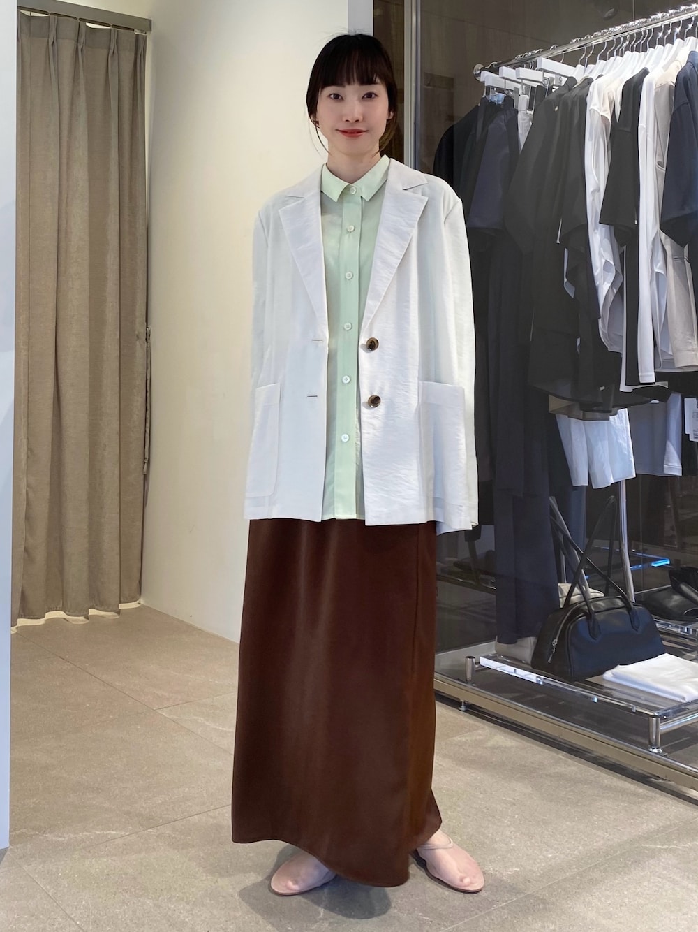グリーン系のシャツ/ブラウス、ベージュ系のテーラードジャケット、ブラウン系のスカートを着用したレディースの冬コーディネートの1枚目の写真
