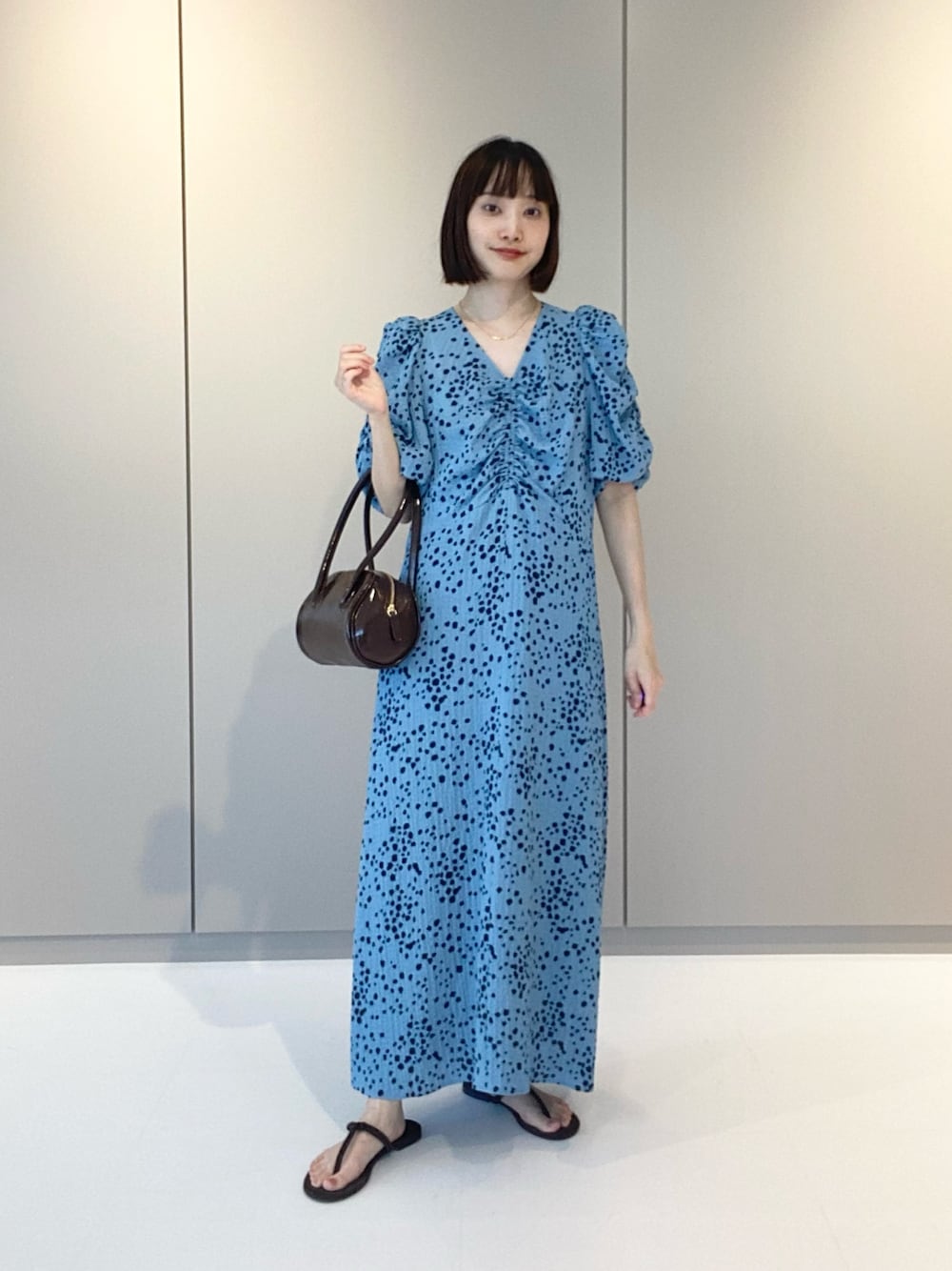 ブルー系のワンピース、ブラウン系のサンダル、ゴールド系のネックレスを着用したレディースの夏コーディネートの1枚目の写真