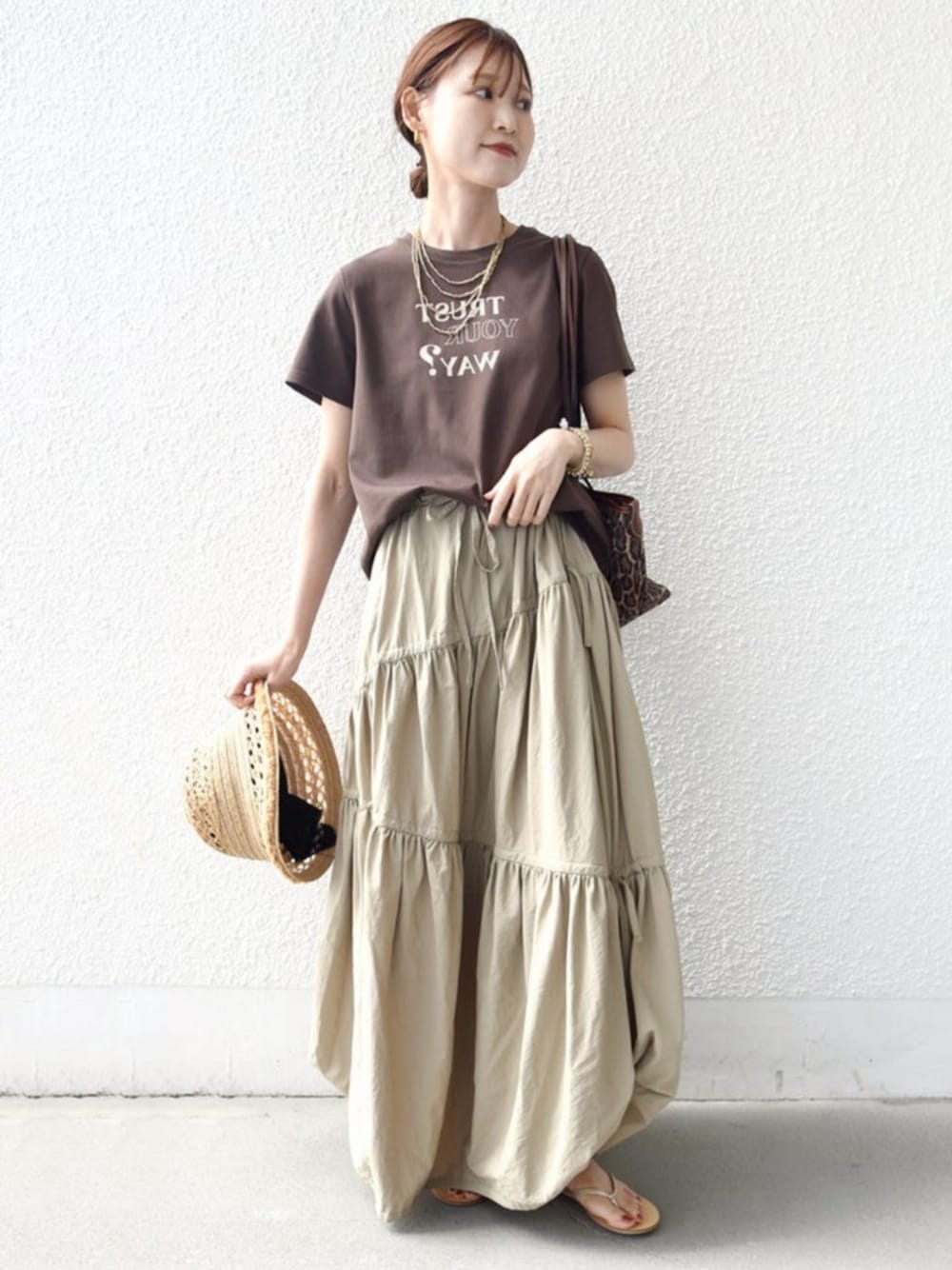 ブラウン系のTシャツ/カットソー、ブラウン系のトートバッグ、ベージュ系のハットを着用したレディースの春コーディネートの1枚目の写真