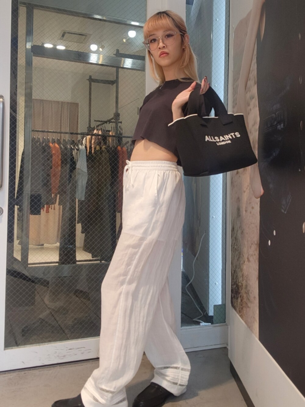 ブラック系のTシャツ/カットソー、ホワイト系のその他パンツ、ブラック系のトートバッグを着用したレディースの夏コーディネートの1枚目の写真