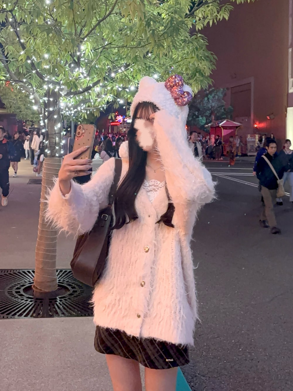 ピンク系のカーディガン/ボレロ、ブラック系のスカート、ブラウン系のボストンバッグを着用したレディースの秋コーディネートの1枚目の写真