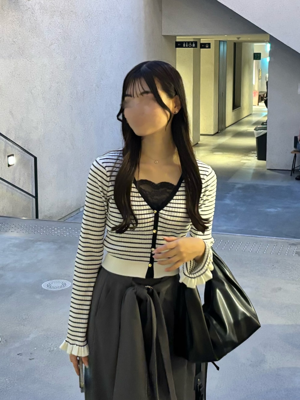 ホワイト系のカーディガン/ボレロ、ブラック系のハンドバッグ、グレー系のスラックスを着用したレディースの秋コーディネートの1枚目の写真