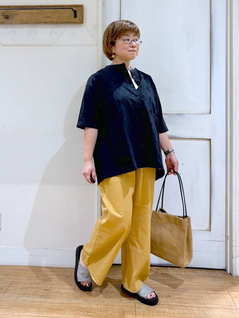 ベージュ系のその他パンツ、ベージュ系のトートバッグ、その他のサンダルを着用したレディースの夏コーディネートの1枚目の写真