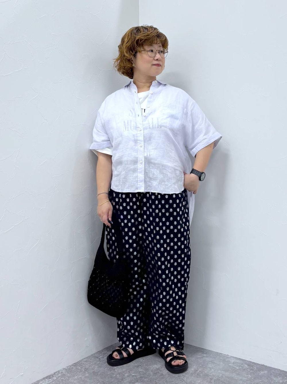 ホワイト系のTシャツ/カットソー、ブラック系のトートバッグ、ブラック系のサンダルを着用したレディースの夏コーディネートの1枚目の写真