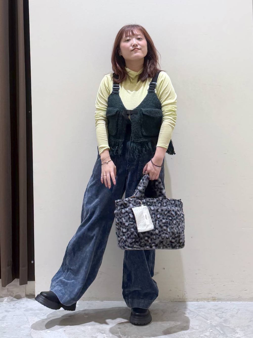 グリーン系のベスト、その他のトートバッグ、イエロー系のTシャツ/カットソーを着用したレディースの秋コーディネートの1枚目の写真
