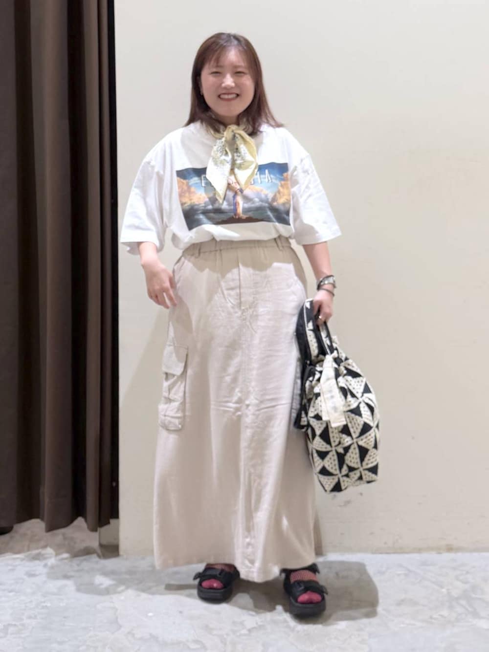 その他のトートバッグ、ベージュ系のスカート、ブラック系のサンダルを着用したレディースの夏コーディネートの1枚目の写真