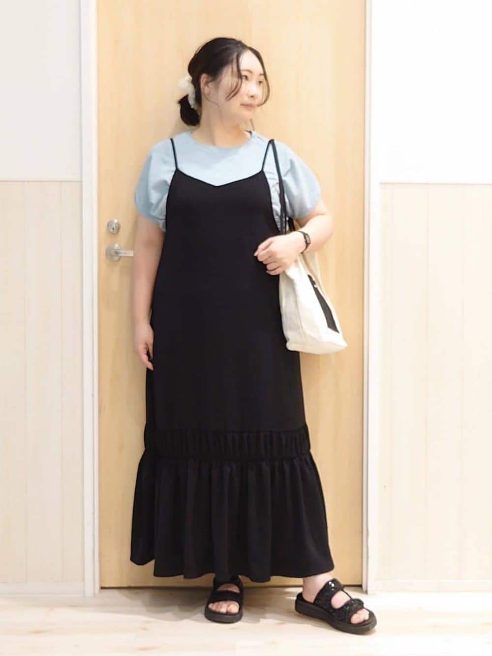 ブラック系のワンピース、ブルー系のTシャツ/カットソー、ブラック系のサンダルを着用したレディースの夏コーディネートの1枚目の写真