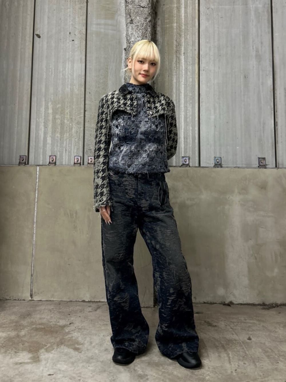 ブラック系のブーツ、ブラック系のデニムパンツ、ブルー系のタンクトップを着用したレディースの冬コーディネートの1枚目の写真