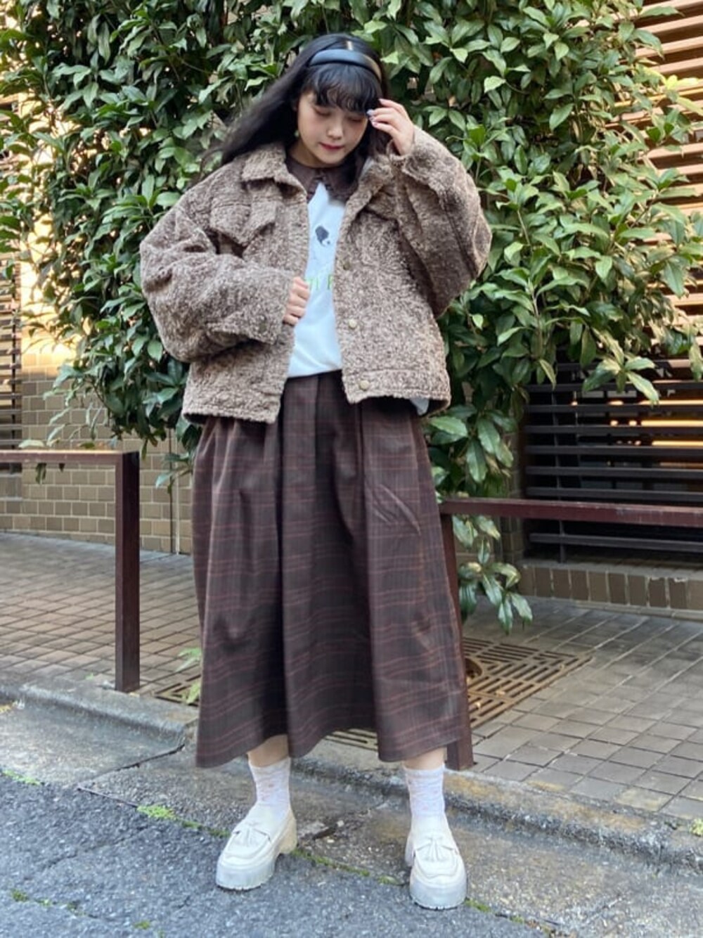 ブラウン系のカバーオール、ブラウン系のワンピース、ホワイト系のローファーを着用したレディースの冬コーディネートの1枚目の写真