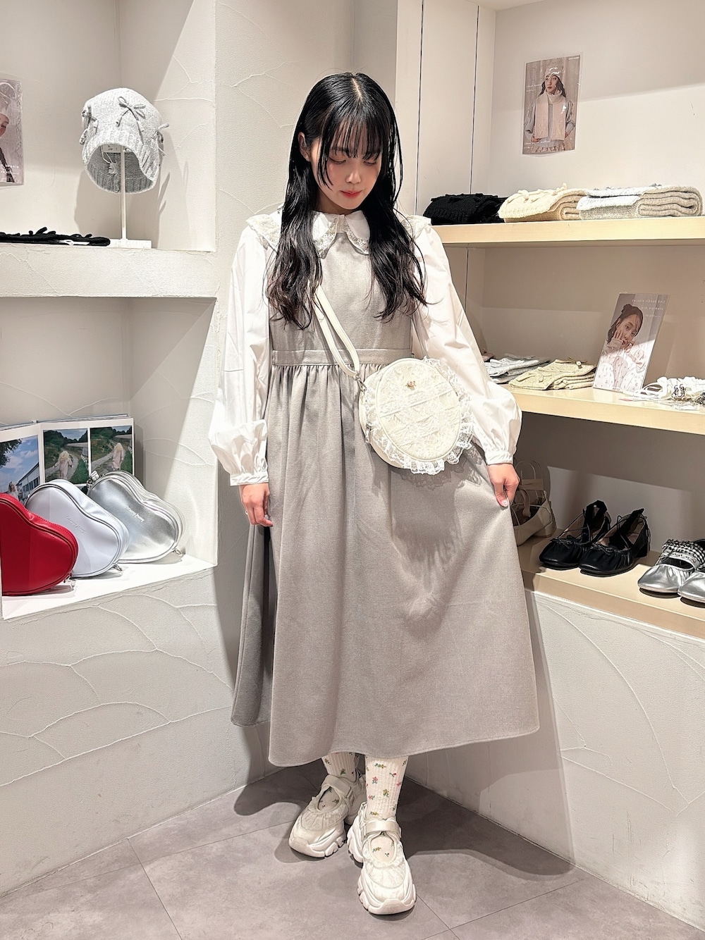 ゴールド系のシャツ/ブラウス、グレー系のワンピース、ホワイト系のショルダーバッグを着用したレディースの秋コーディネートの1枚目の写真