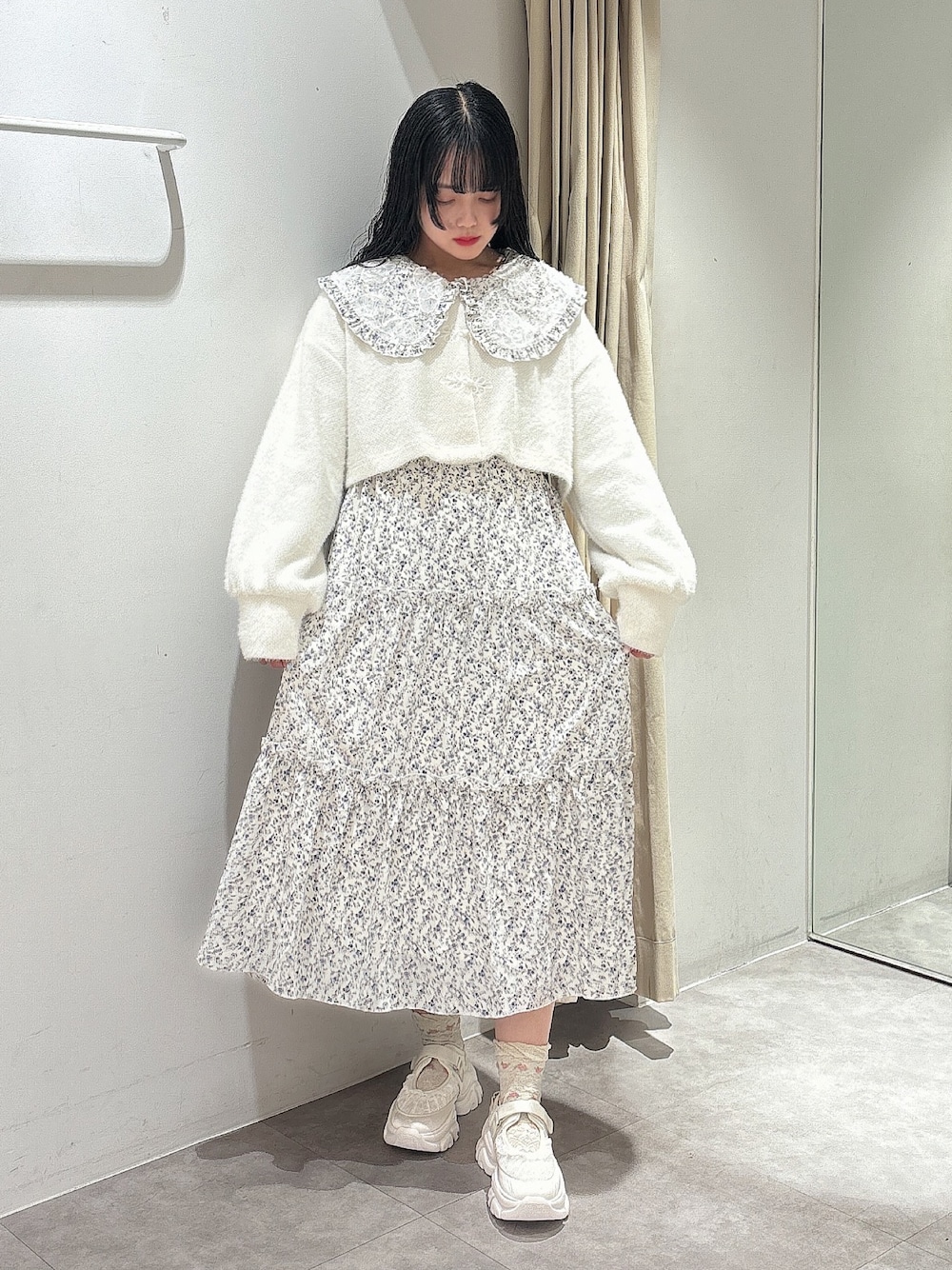 ホワイト系のカーディガン/ボレロ、ホワイト系のワンピース、ホワイト系のスニーカーを着用したレディースの秋コーディネートの1枚目の写真