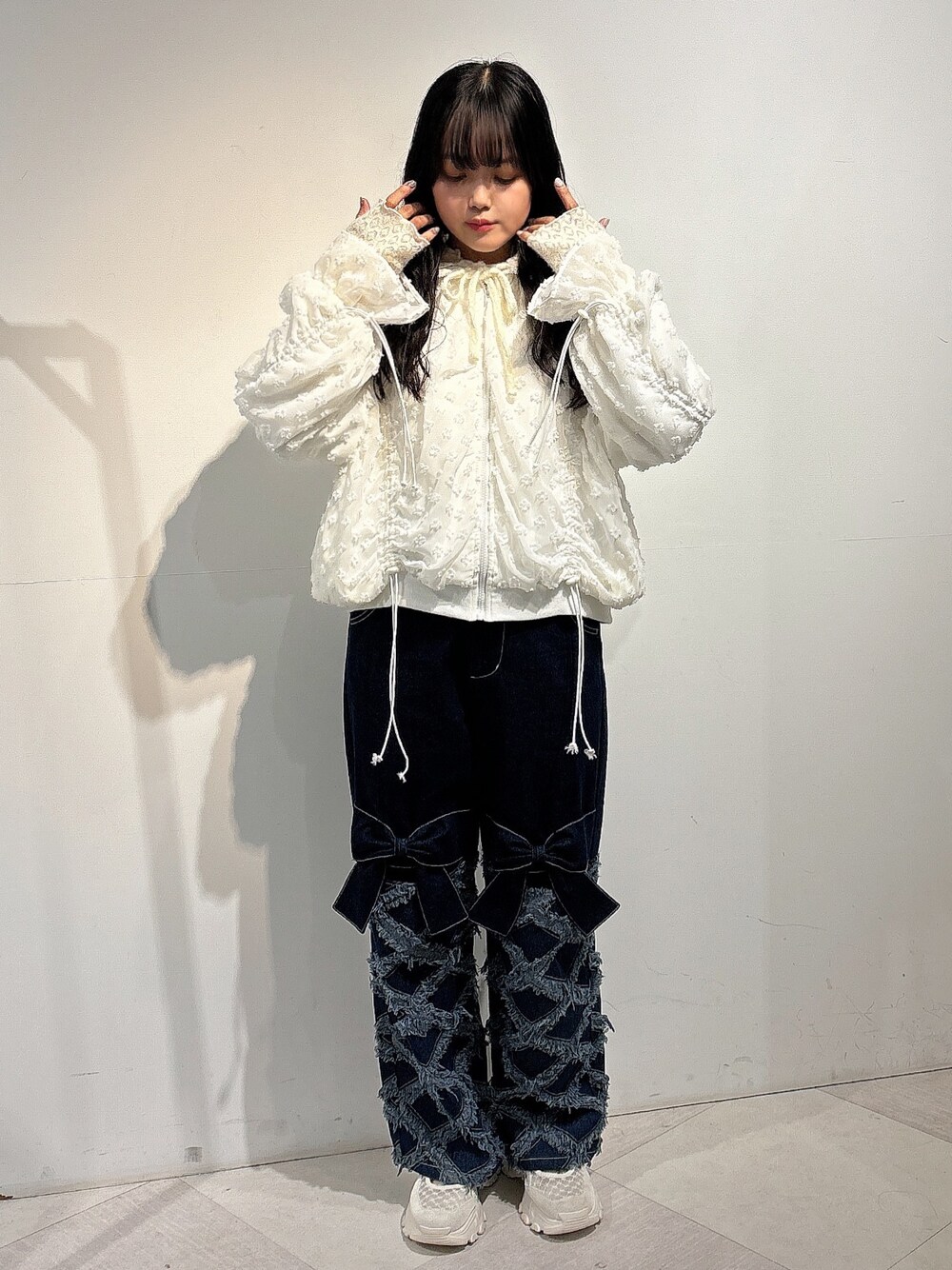 ホワイト系のジャージ、ブルー系のデニムパンツ、ホワイト系のスニーカーを着用したレディースの秋コーディネートの1枚目の写真