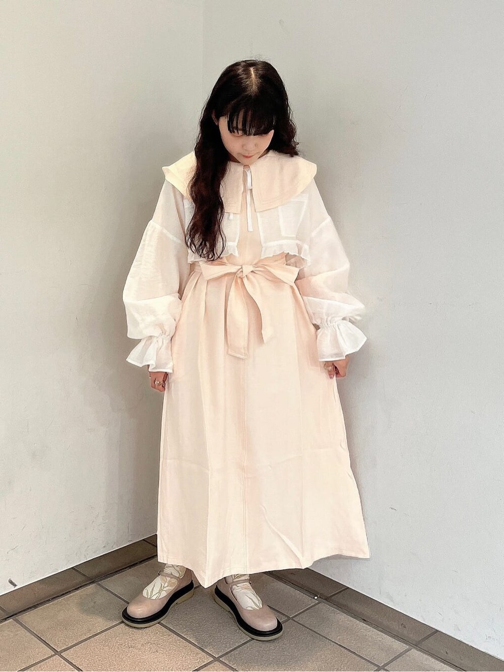 ベージュ系のパンプス、ホワイト系のワンピース、ホワイト系のシャツ/ブラウスを着用したレディースの秋コーディネートの1枚目の写真