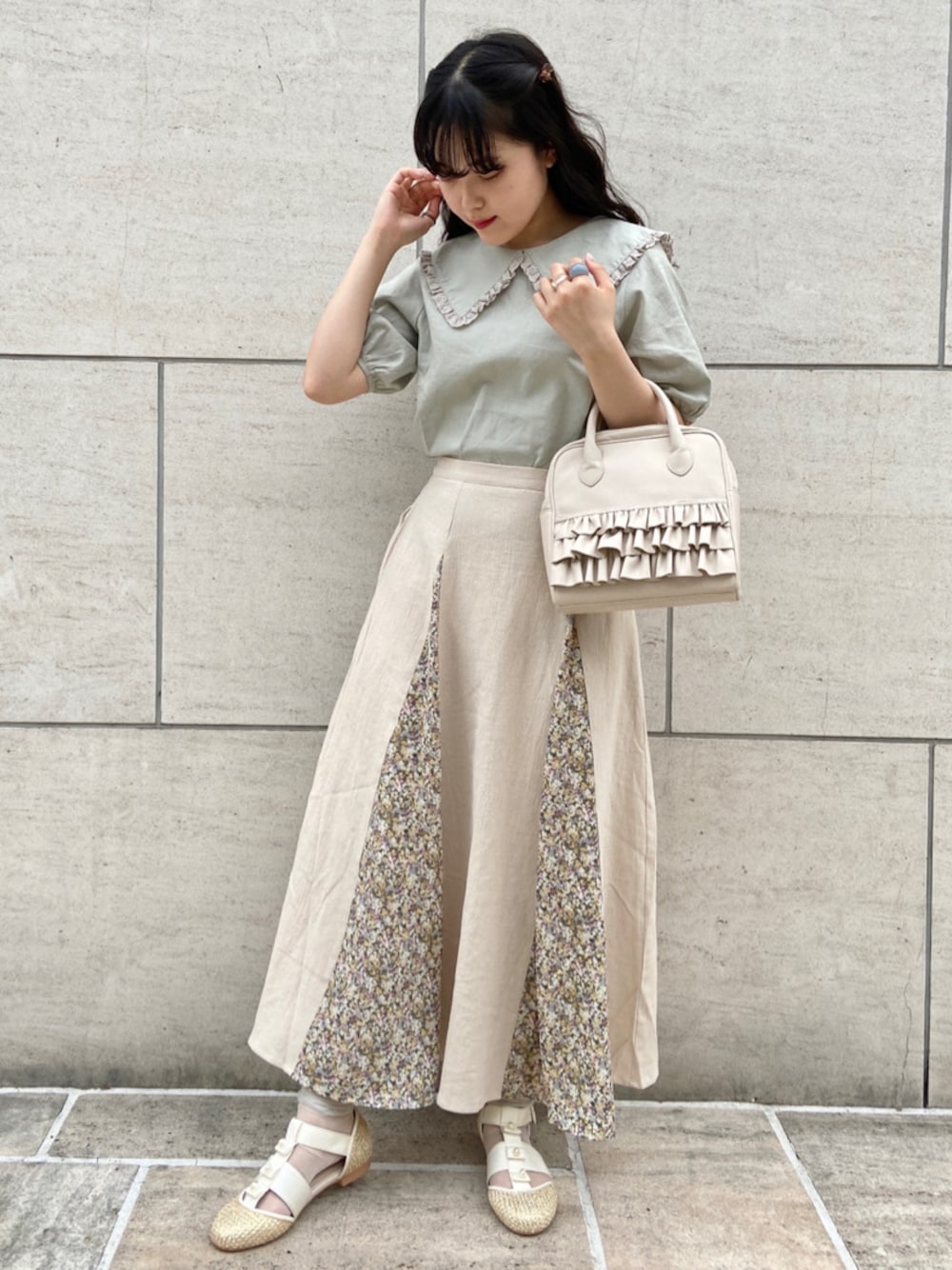 ベージュ系のパンプス、グリーン系のシャツ/ブラウス、ベージュ系のスカートを着用したレディースの夏コーディネートの1枚目の写真