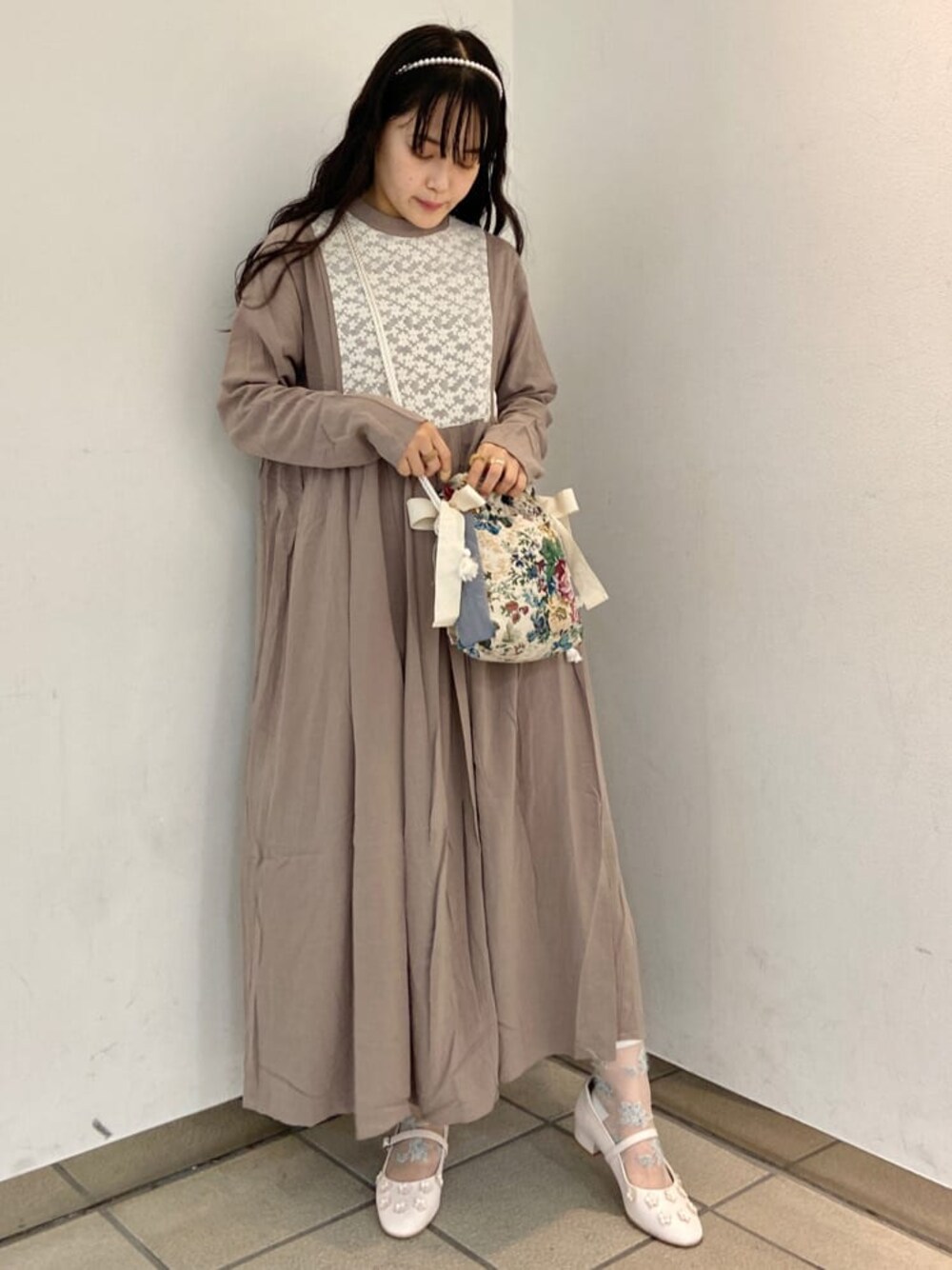 ベージュ系のワンピース、ホワイト系のパンプス、ホワイト系のハンドバッグを着用したレディースの夏コーディネートの1枚目の写真