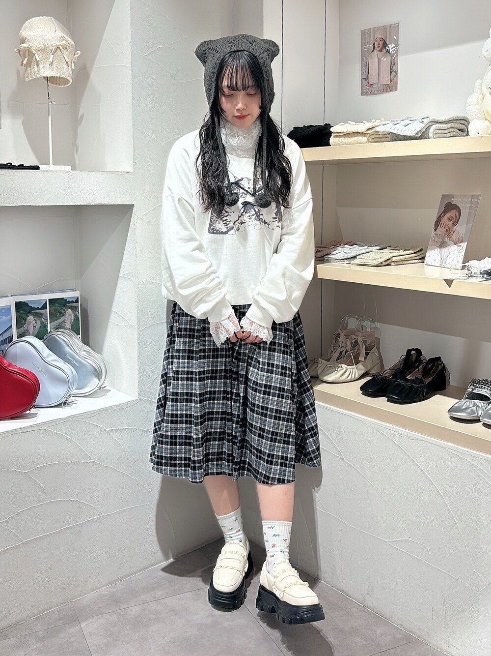 ホワイト系のニット/セーター、ホワイト系のスウェット、ブラック系のスカートを着用したレディースの秋コーディネートの1枚目の写真