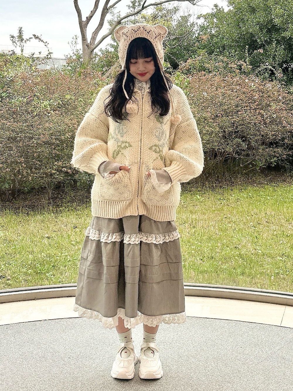 ブルー系のカーディガン/ボレロ、グレー系のニット/セーター、グレー系のスカートを着用したレディースの冬コーディネートの1枚目の写真