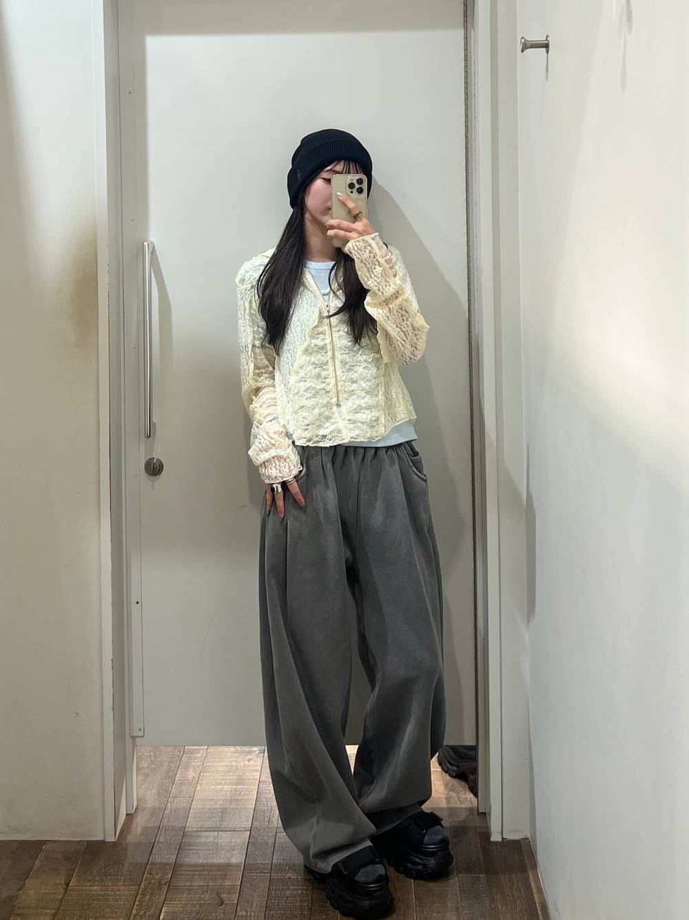 グレー系のスウェットパンツ、ホワイト系のパーカー、ブラック系のサンダルを着用したレディースの春コーディネートの1枚目の写真