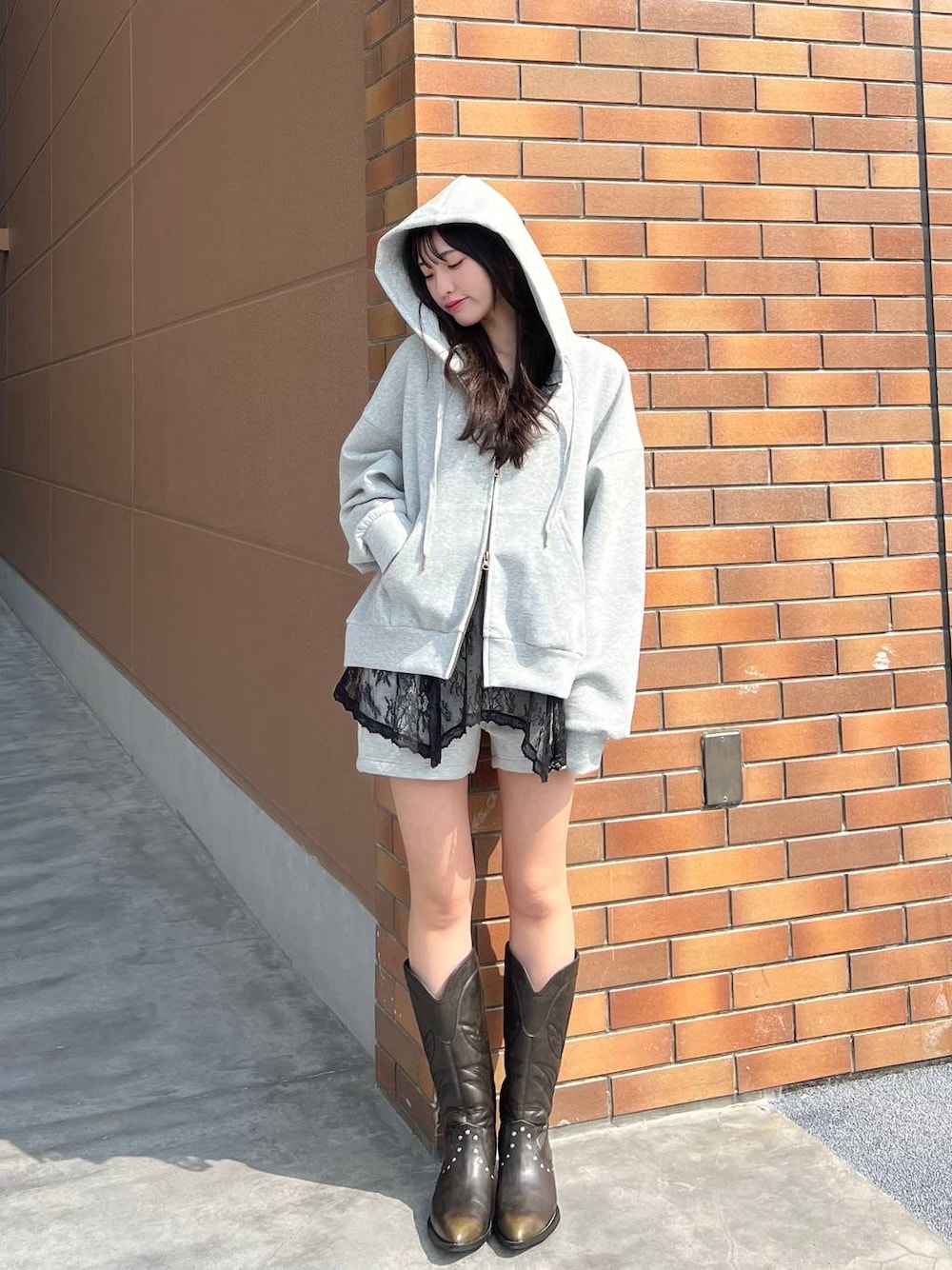 ブラック系のブーツ、グレー系のスウェットパンツ、グレー系のパーカーを着用したレディースの春コーディネートの1枚目の写真