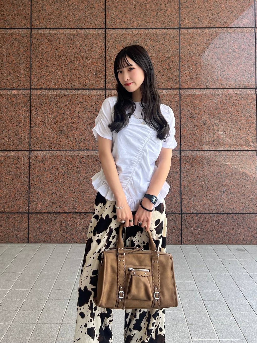 ベージュ系のその他パンツ、ブラウン系のボストンバッグ、ブラック系のサンダルを着用したレディースの夏コーディネートの1枚目の写真