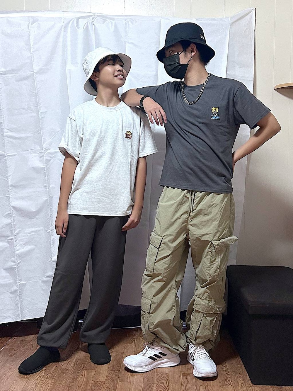 ブラック系のTシャツ/カットソー、ホワイト系のTシャツ/カットソー、ブラウン系のスウェットパンツを着用したキッズの秋コーディネートの1枚目の写真