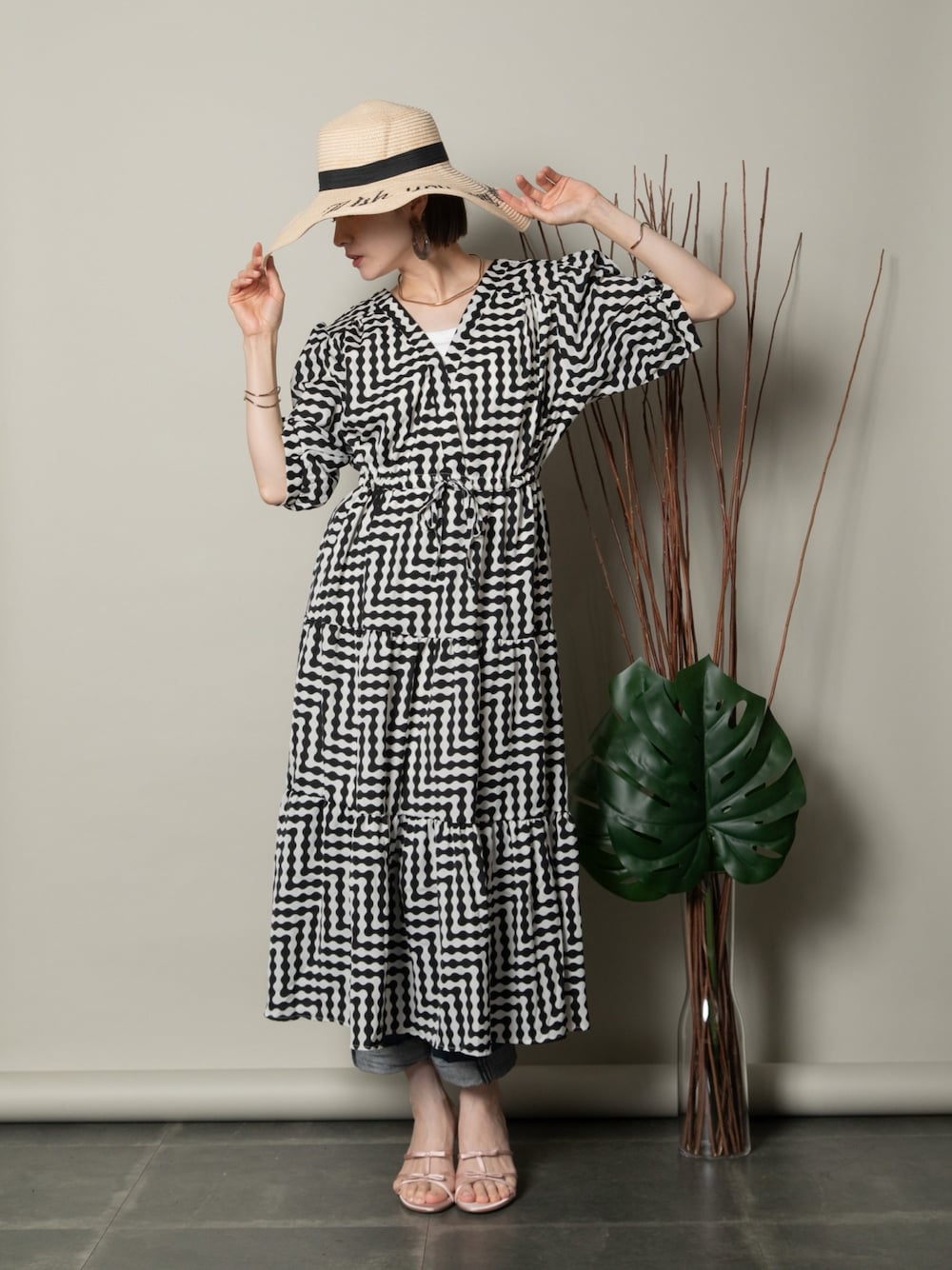 ブラック系のワンピース、ブルー系のデニムパンツ、ピンク系のサンダルを着用したレディースの夏コーディネートの1枚目の写真