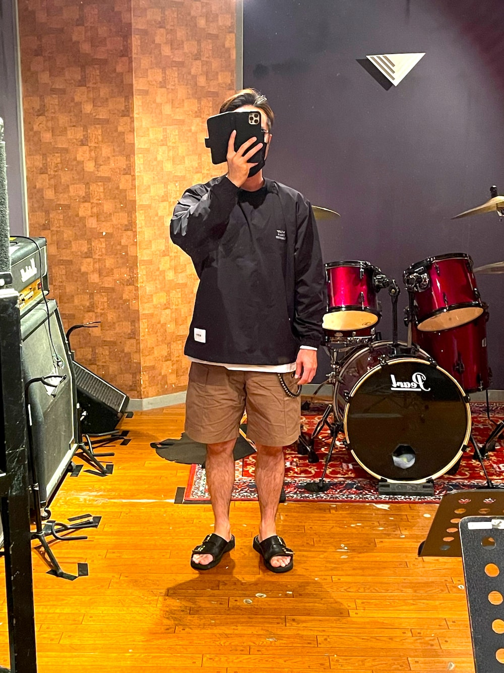 ブラック系のトップス、ベージュ系のカーゴパンツ、ブラック系のサンダルを着用したメンズの夏コーディネートの1枚目の写真