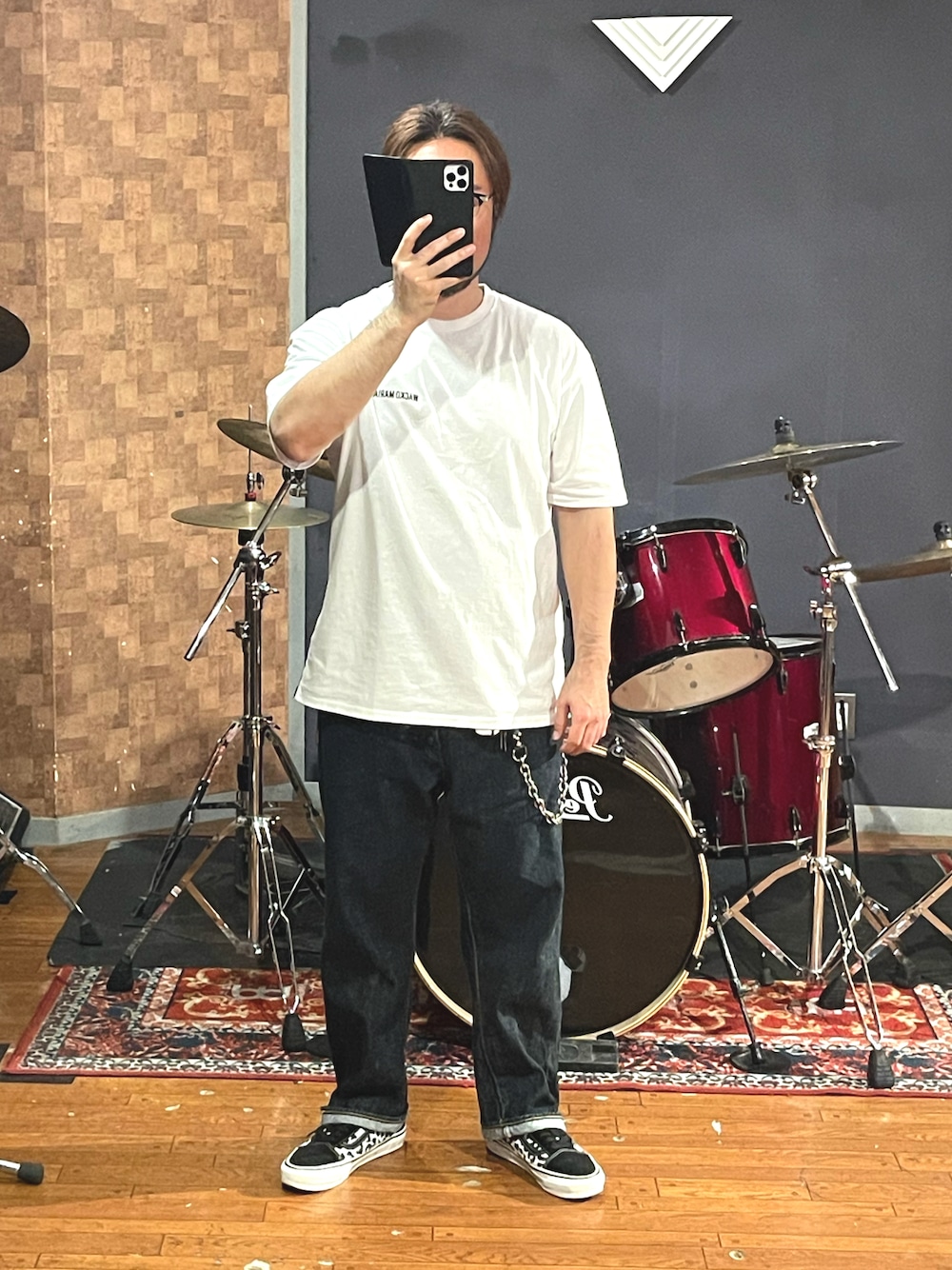 ホワイト系のTシャツ/カットソー、ブルー系のデニムパンツ、ブラック系のスニーカーを着用したメンズの秋コーディネートの1枚目の写真