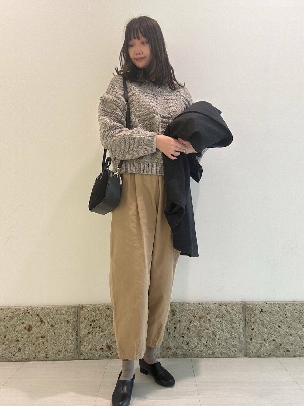 グレー系のニット/セーター、ブラック系のショルダーバッグ、ブラック系のその他シューズを着用したレディースの秋コーディネートの1枚目の写真