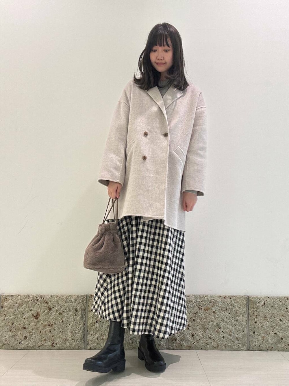 ベージュ系のその他アウター、ブラック系のブーツ、ブラウン系のショルダーバッグを着用したレディースの秋コーディネートの1枚目の写真