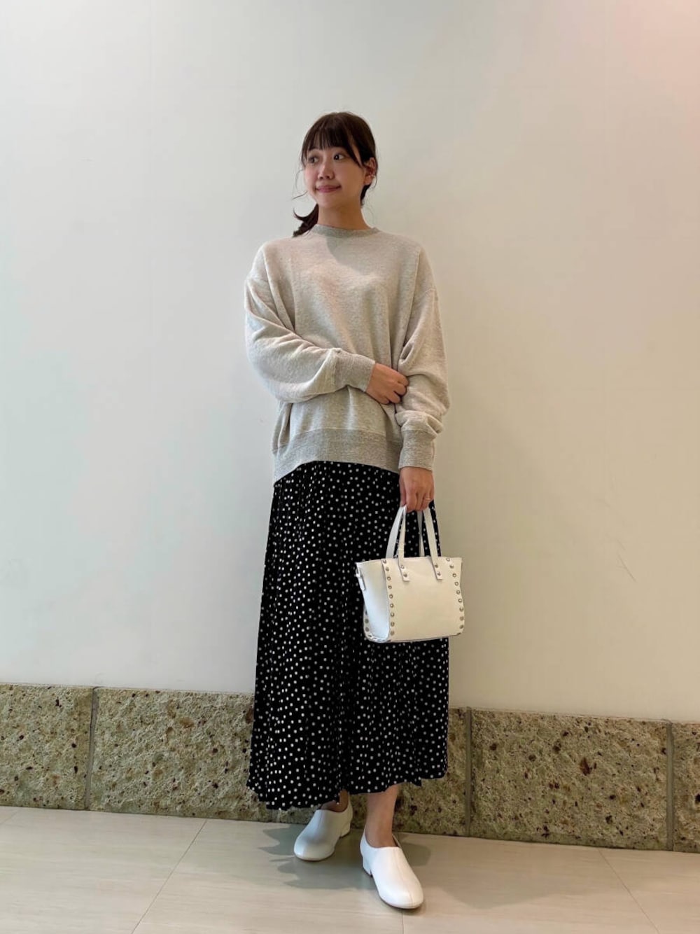 ホワイト系のショルダーバッグ、ホワイト系のその他シューズ、グレー系のスウェットを着用したレディースの秋コーディネートの1枚目の写真