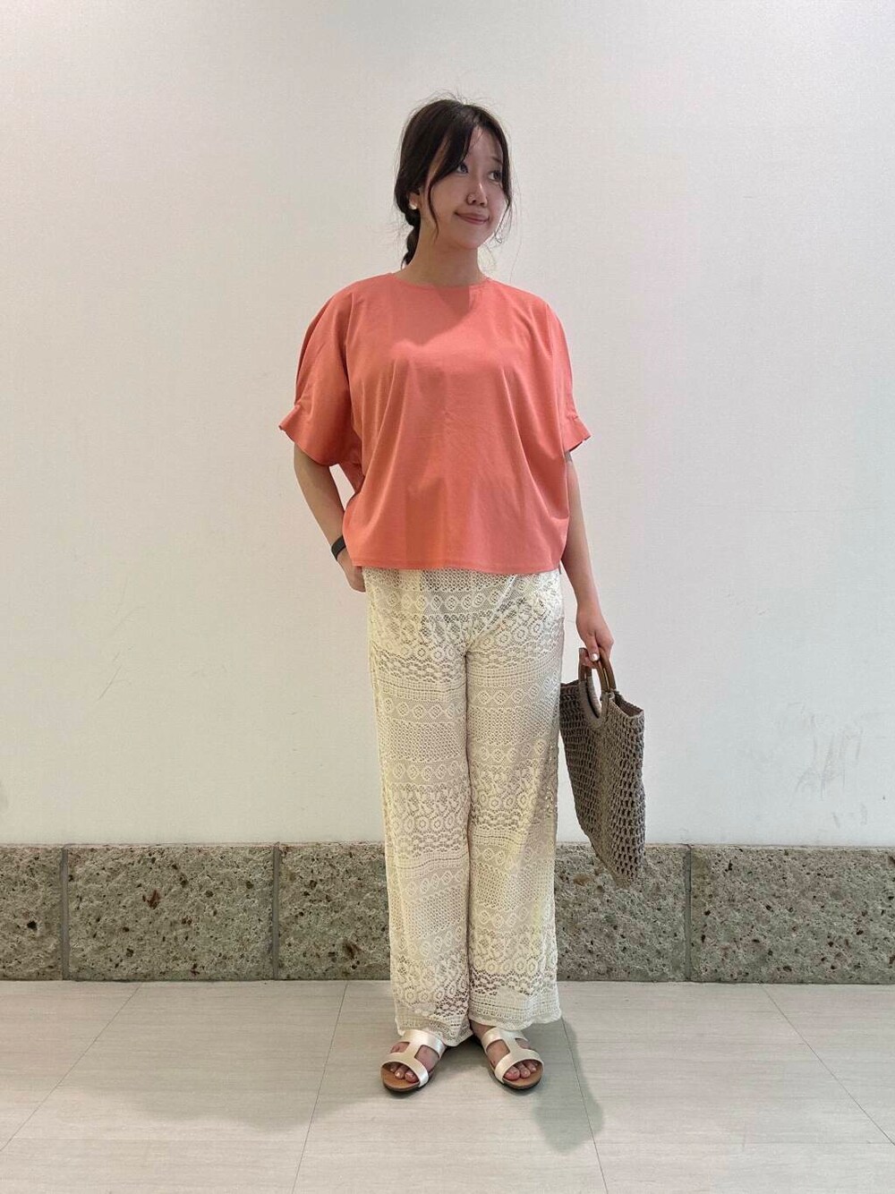 グレー系のトートバッグ、ホワイト系のその他パンツ、オレンジ系のTシャツ/カットソーを着用したレディースの夏コーディネートの1枚目の写真