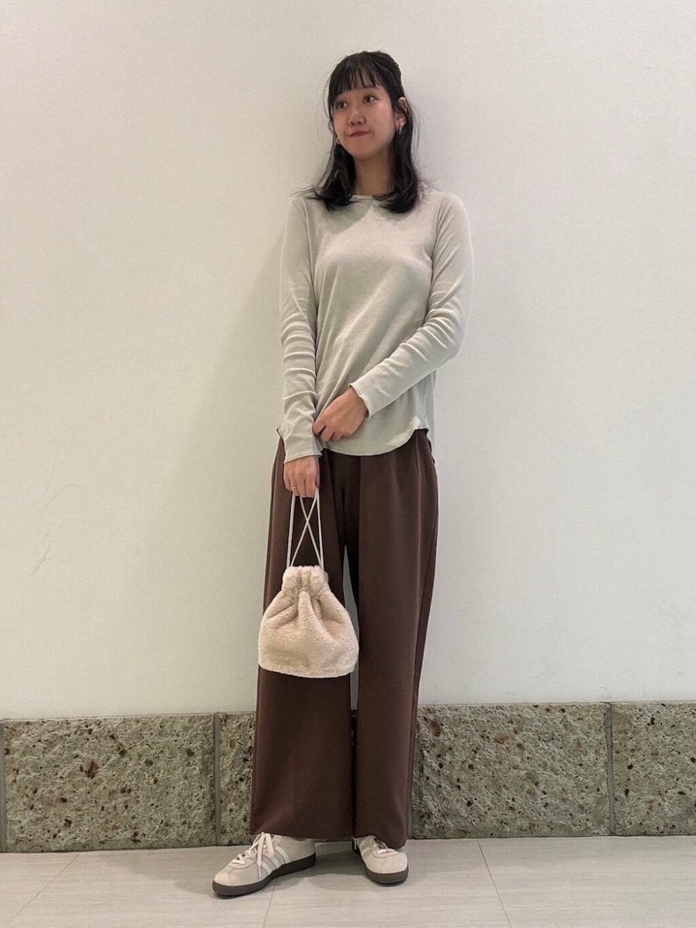 ブラウン系のその他パンツ、ホワイト系のスニーカー、グレー系のTシャツ/カットソーを着用したレディースの秋コーディネートの1枚目の写真