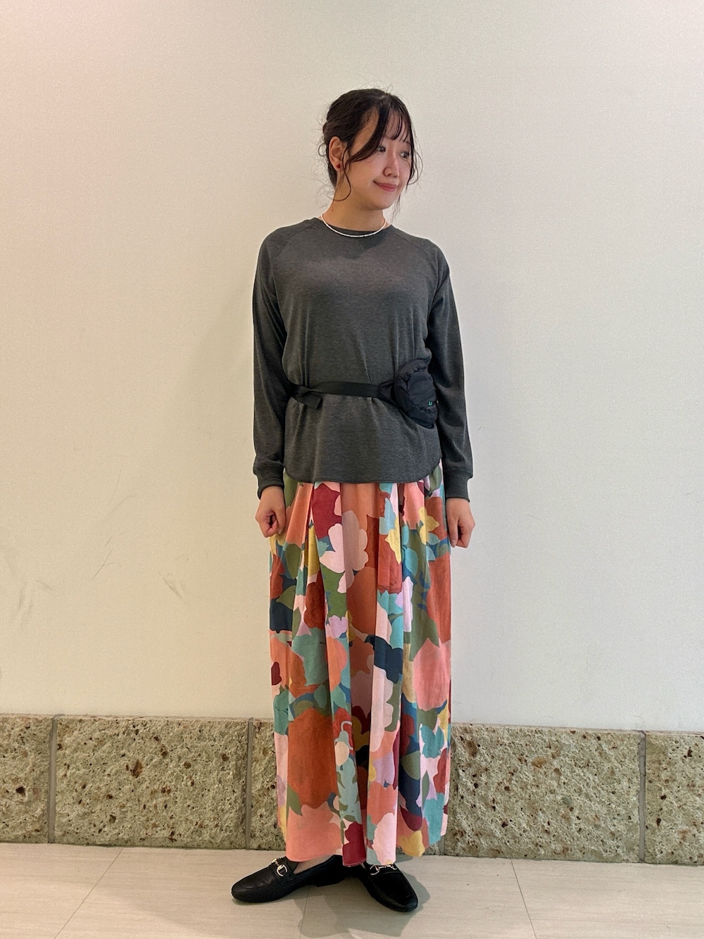 ブラック系のショルダーバッグ、グレー系のTシャツ/カットソー、ブラック系のパンプスを着用したレディースの秋コーディネートの1枚目の写真