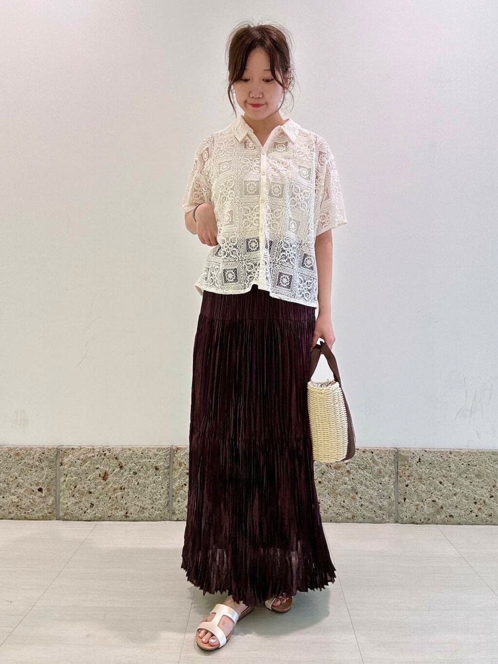 ホワイト系のハンドバッグ、ホワイト系のタンクトップ、ブラウン系のスカートを着用したレディースの夏コーディネートの1枚目の写真