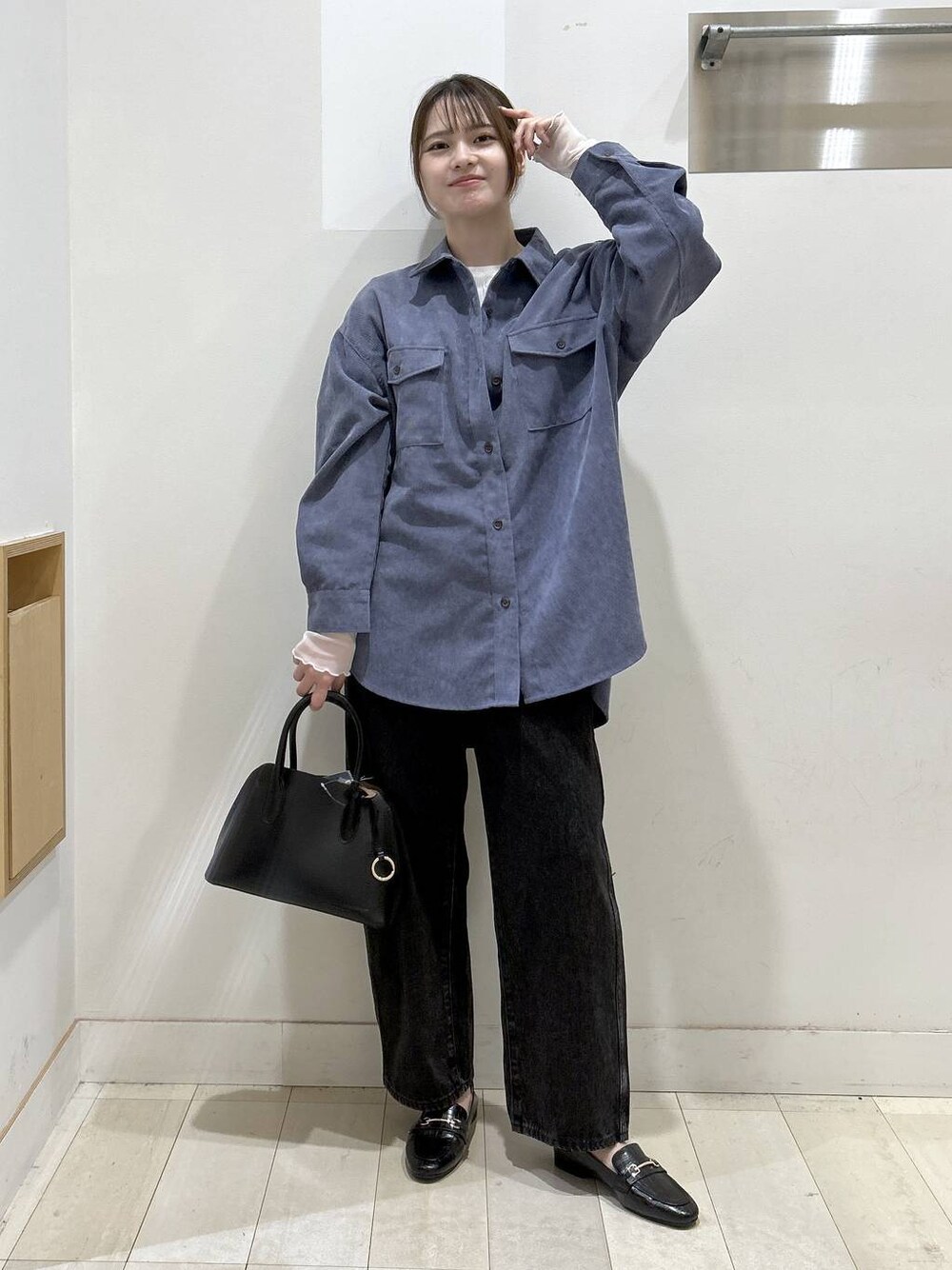 ブラック系のローファー、ブラック系のショルダーバッグ、ブラック系のデニムパンツを着用したレディースの秋コーディネートの1枚目の写真