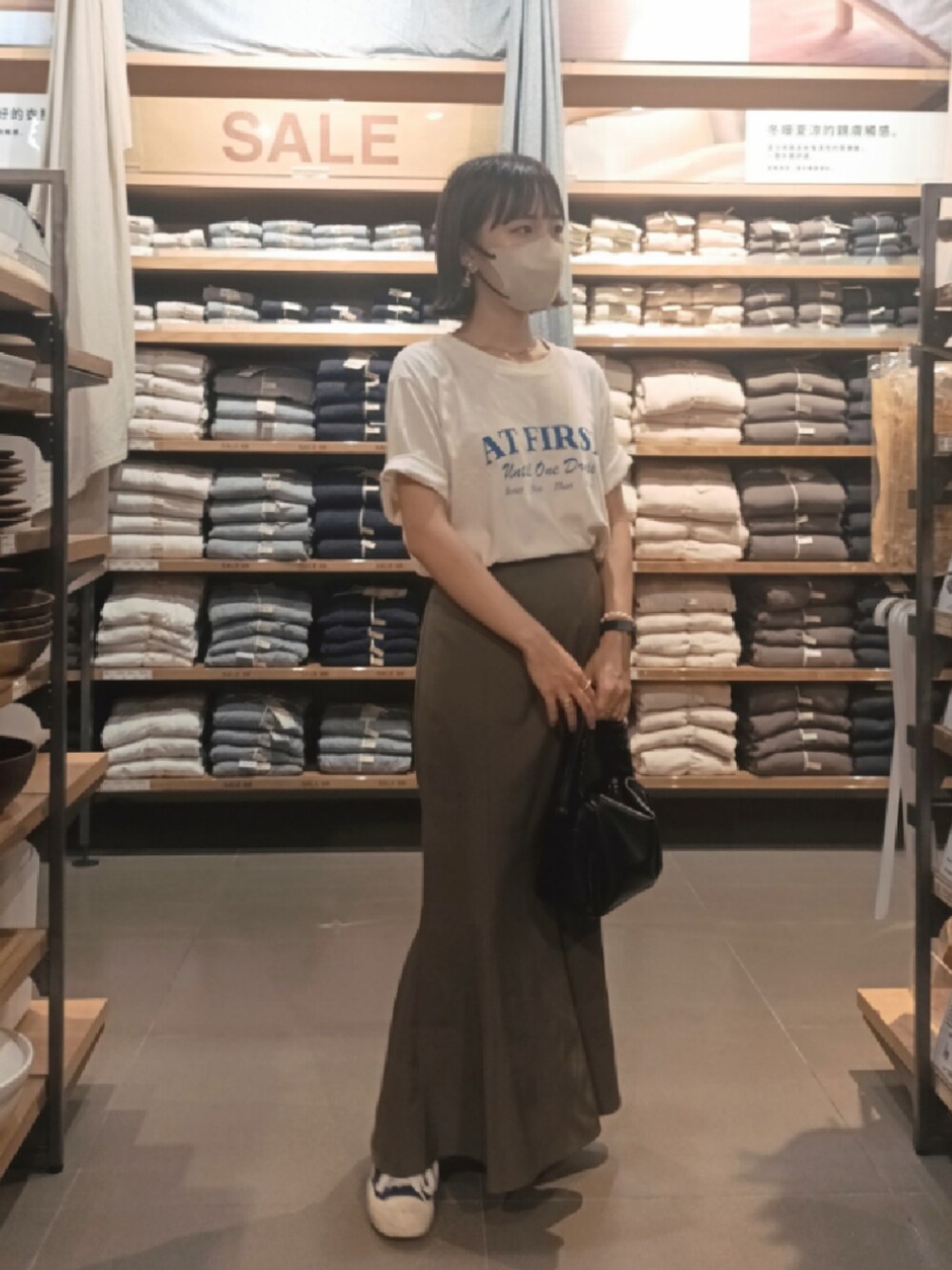 ブルー系のTシャツ/カットソー、ブラック系のハンドバッグ、ブラウン系のスカートを着用したレディースの夏コーディネートの1枚目の写真